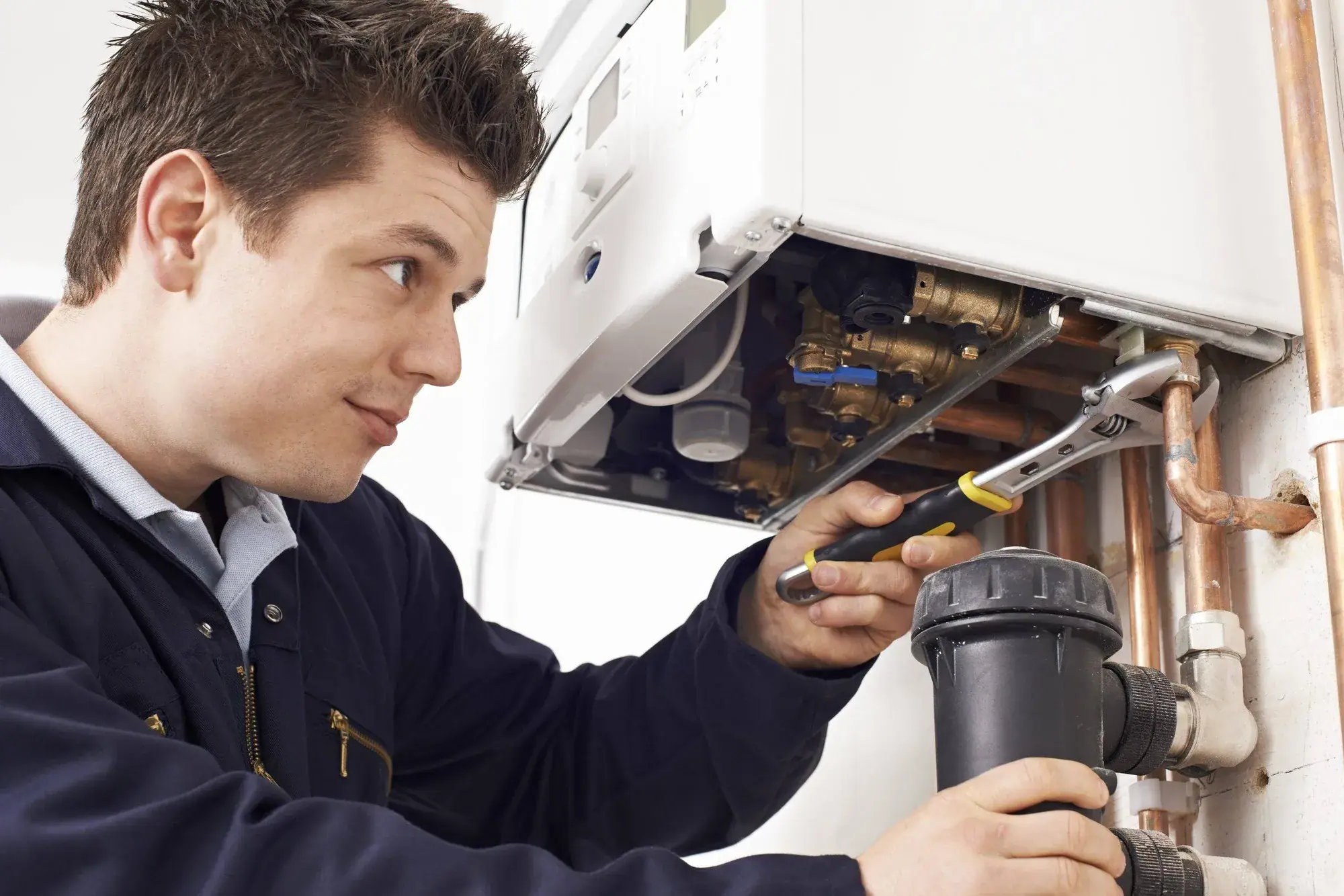 Installateur repariert die geöffnete Gastherme bei einem Notdiensteinsatz